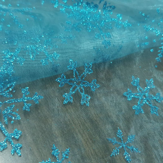 Organza Turquoise Ice Flakes fabric - Semi-transparent organza fabric with glitter and turquoise fall with bright ice flakes. Ideal for ice princess costume (Frozen), decorations and much more. The fabric is 150cm wide and its composition 100% polyester.
