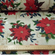 Canvas Christmas Poinsettia fabric - Decorative Christmas-themed canvas fabric where drawings of the Christmas flower, also called poinsettia, appear on a light background with golden letters. The fabric is 280cm wide and its composition is 70% cotton -