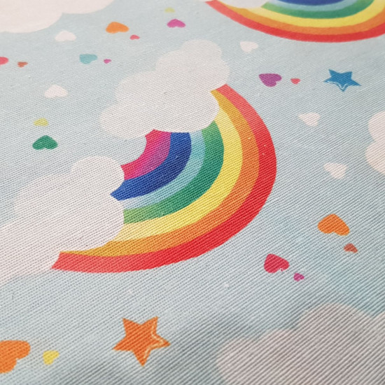 Canvas Rainbow Clouds Stars fabric - Decorative canvas fabric with drawings of rainbows, clouds, stars and colored hearts on a blue background. Ideal fabric for children's theme decoration. The fabric is 280cm wide and its composition is 70% cotton