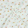 Tela Doble Gasa Hojas - Tela muselina o doble gasa algodón orgánico con dibujos de hojas de colores sobre un fondo blanco. La tela mide 135cm de ancho y su composición 100% algodón.