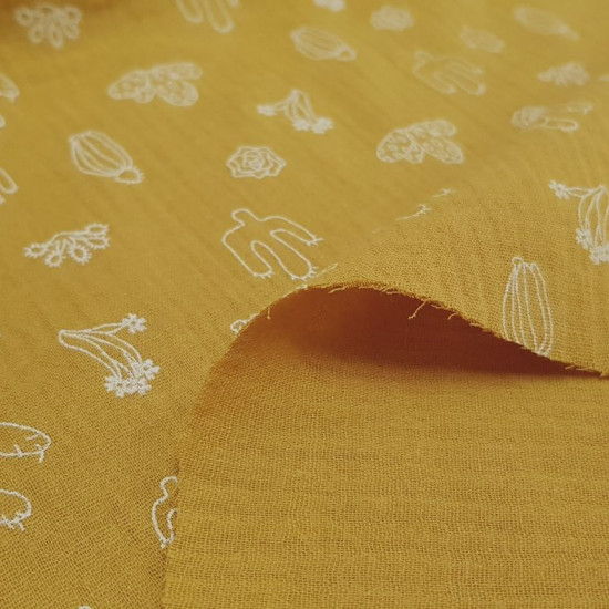 Double Gauze Cactus Ocher fabric - Double gauze or muslin fabric with drawings of various types of cactus in white strokes on an ocher background. The fabric is 130cm wide and its composition is 100% cotton.
