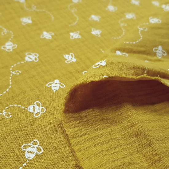 Tela Doble Gasa Abejas - Tela de doble gasa o muselina muy ligera con dibujos de abejas sobre un fondo color ocre. La tela mide 135cm de ancho y su composición 100% algodón.