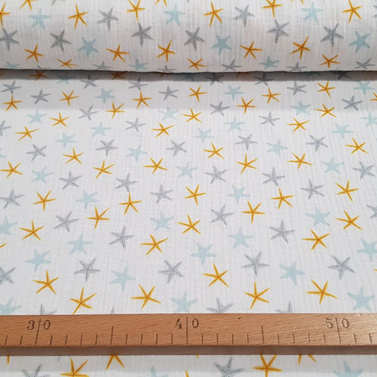 Doble Gasa Estrellas de Mar - Tela de doble gasa algodón con dibujos de estrellas de mar de colores, sobre un fondo blanco. Una tela de temática marinera o veraniega, que nos recuerda el olor a playa. La tela mide 135cm de ancho y s