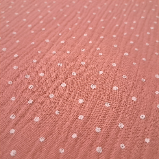 Detalle de tela doble gasa rosa y verde con estampado de puntos blancos