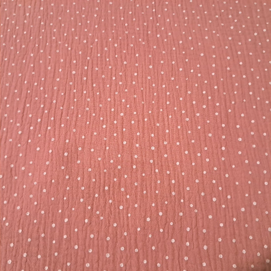 Detalle de tela doble gasa rosa y verde con estampado de puntos blancos