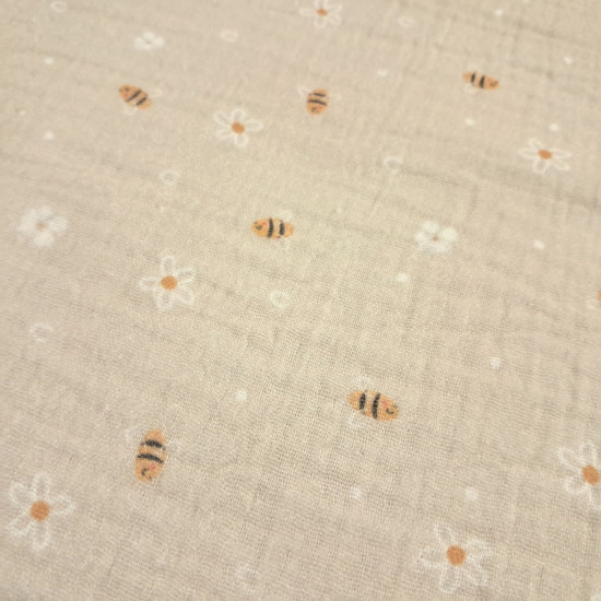 Double Gauze Bees Flowers fabric - Very lightweight double gauze cotton fabric with bee and flower designs on a beige background. The fabric is 135cm wide and 100% cotton.