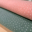 Detalle de tela doble gasa rosa y verde con estampado de puntos blancos
