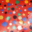 Satin Topos Multicolor Red Background fabric - Satin fabric, bright on one side and with a lot of fall. Polka dot print in various colors on red background. Ideal for clown costume. The fabric is 150cm wide and its composition 100% polyester.