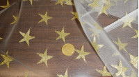 Tela Tul Lurex Estrellas - Tejido semi-transparente de tul tipo rejilla de color blanco con estrellas lurex en color dorado. Es la tela perfecta para disfraces de fantasía, hadas, magía y también para navidad.
