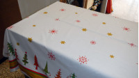 Tela Mantelería Navidad - Tejido ideal para mantelería con dibujos de abetos de navidad y estrellas sobre fondo blanco. Lleva una franja en los bordes del tejido